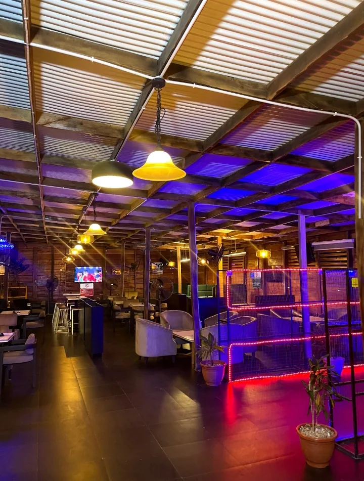 The covered lounge terrace at Blinkx, lit in blue and red