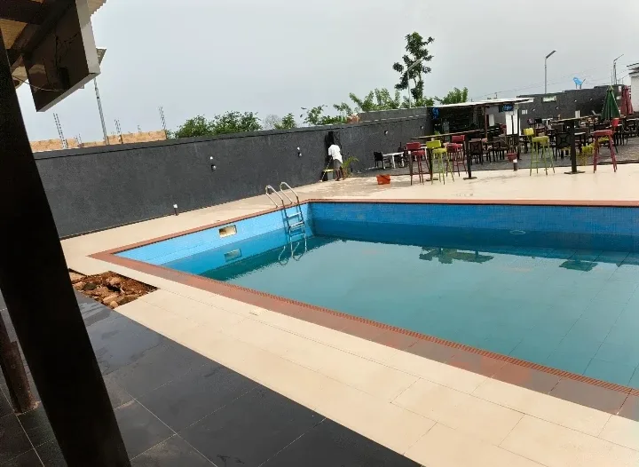 The Blinkx swimming pool, tiled blue, poolside tables behind